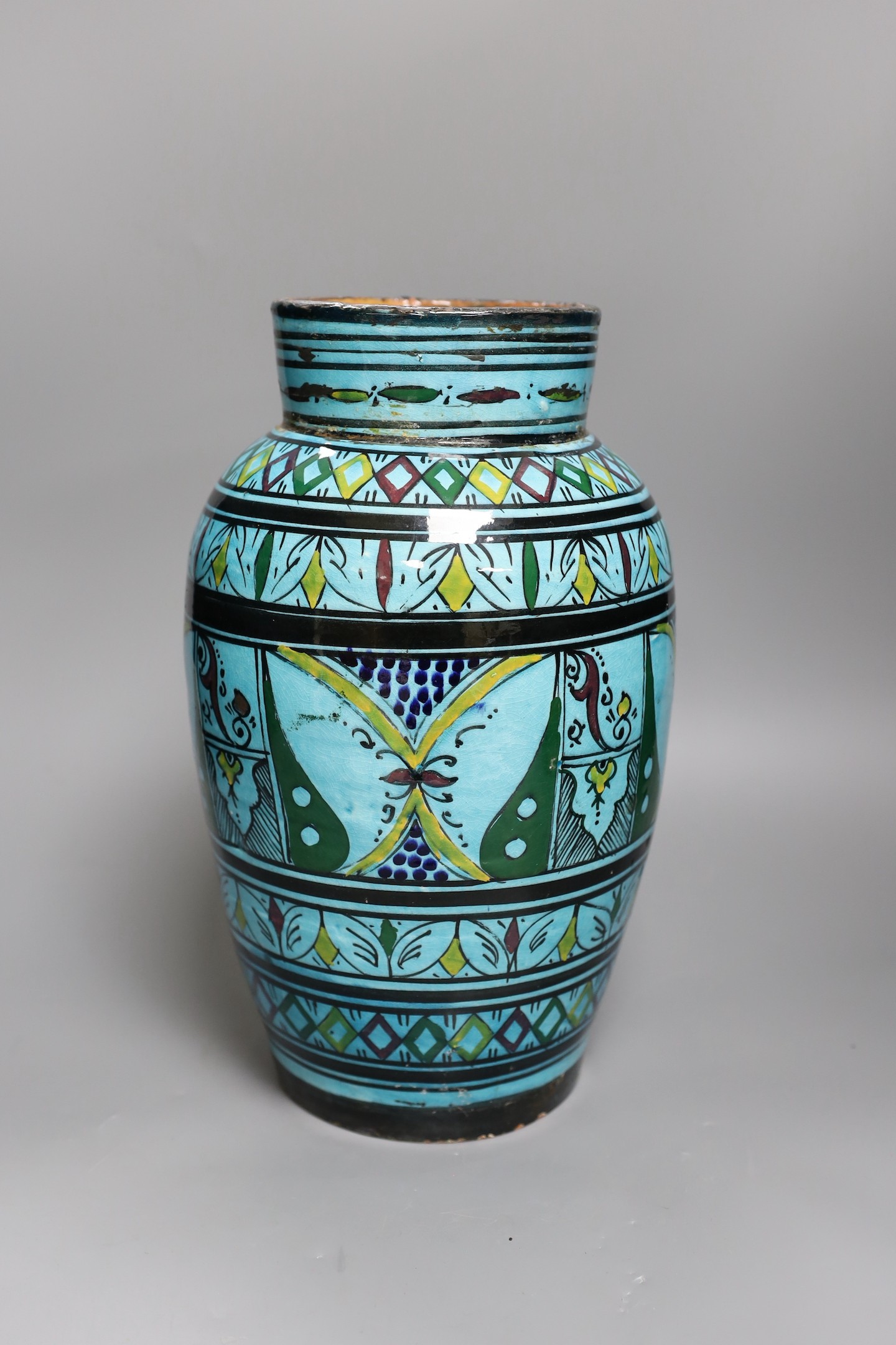 A large Persian ovoid painted terracotta vase, 34cm
